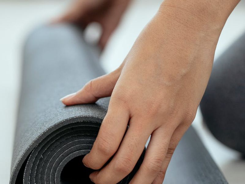 A clean, open space with a yoga mat and a single dumbbell, ready for a workout.